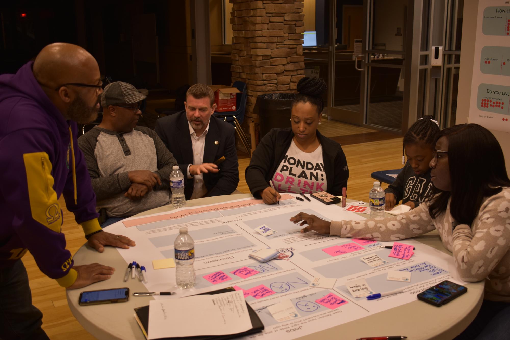 Community members gather around a table to discuss Zebulon planning.