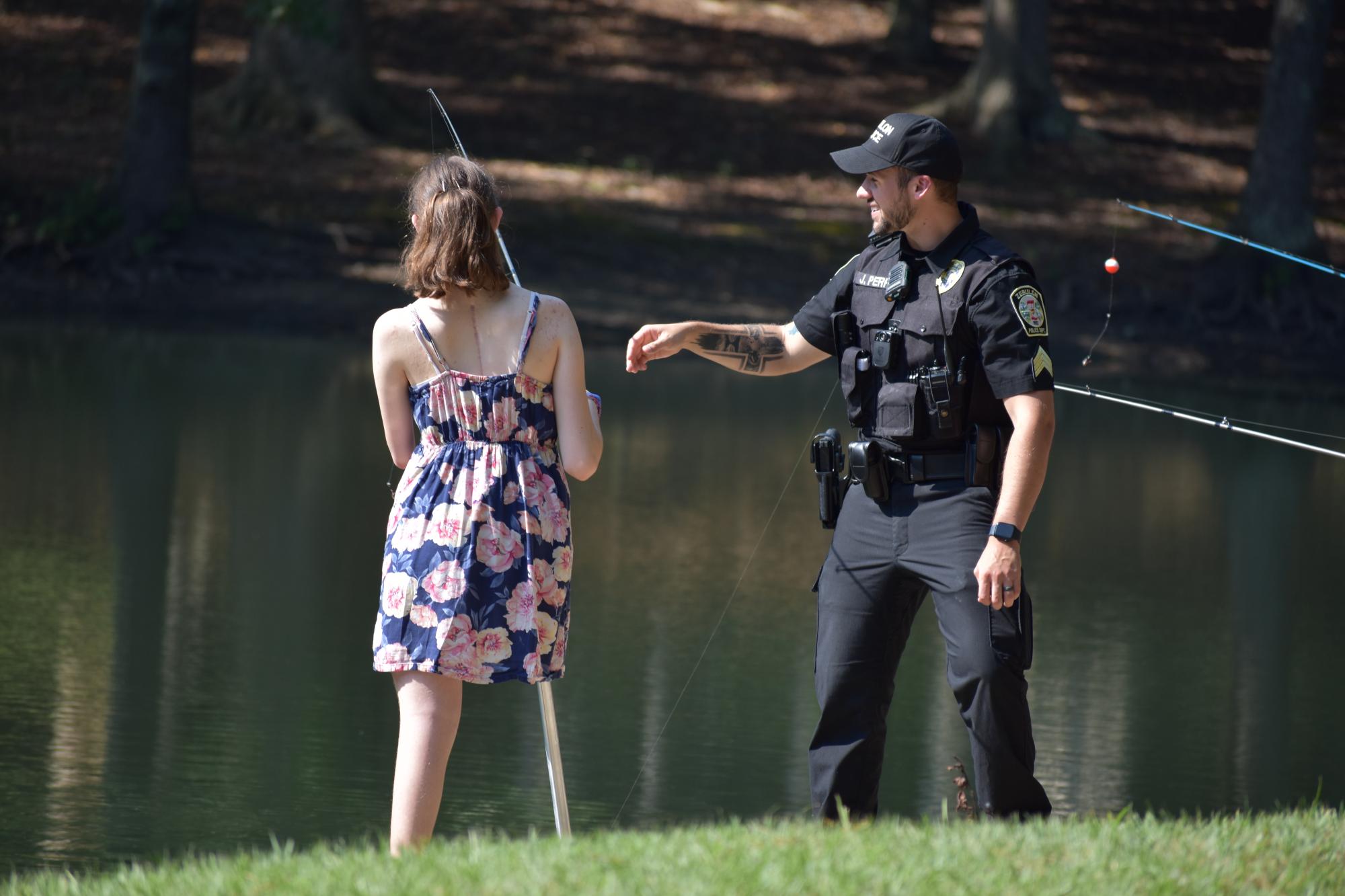 A ZPD officer fishing with a community child.