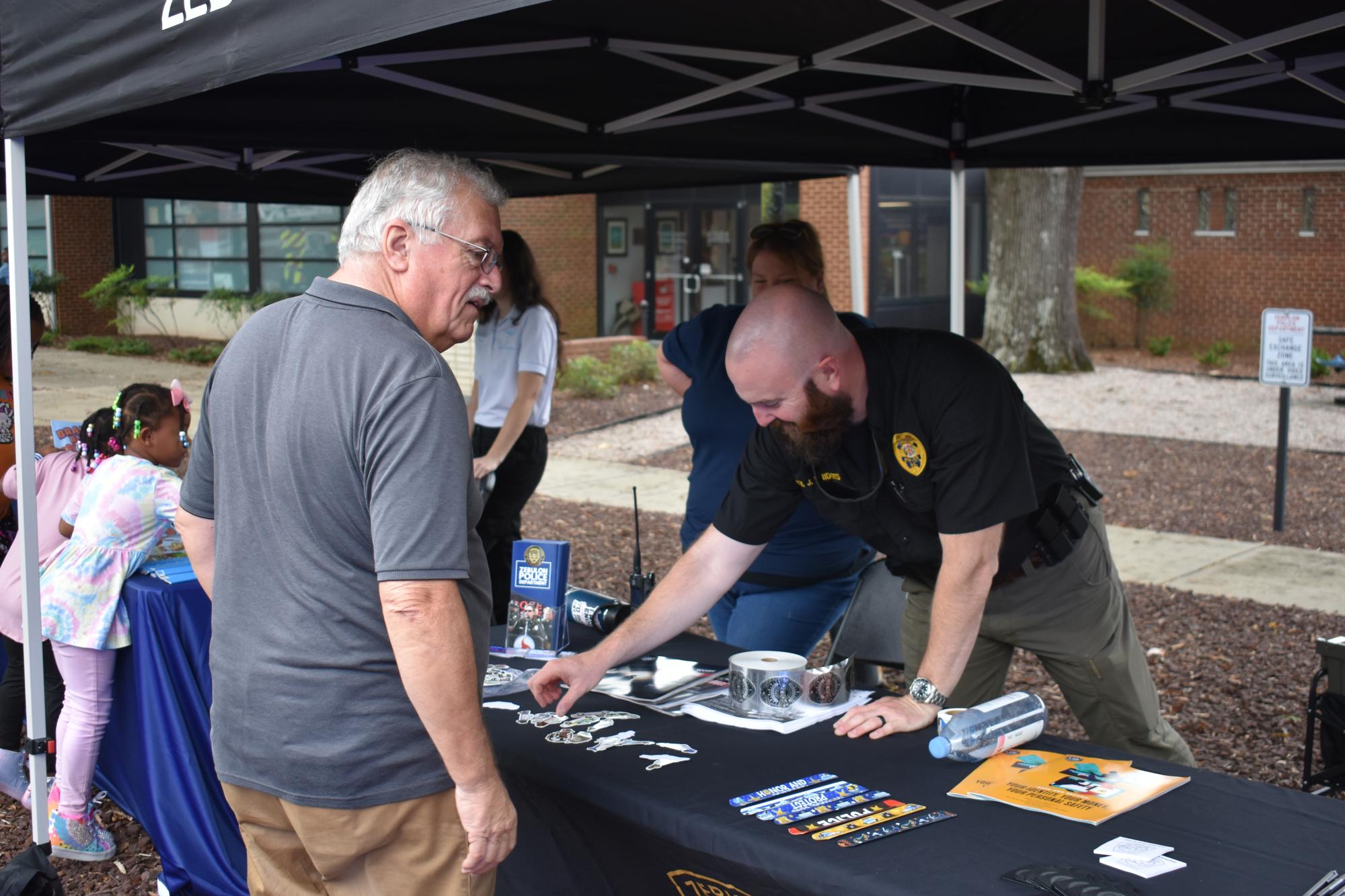 A ZPD officer showing items to a member of the community.